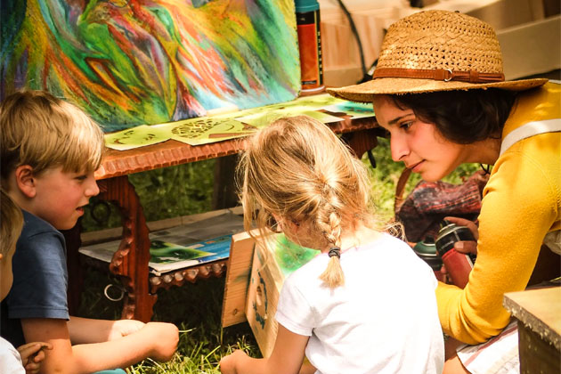 Une femme apprend à des enfants à peindre